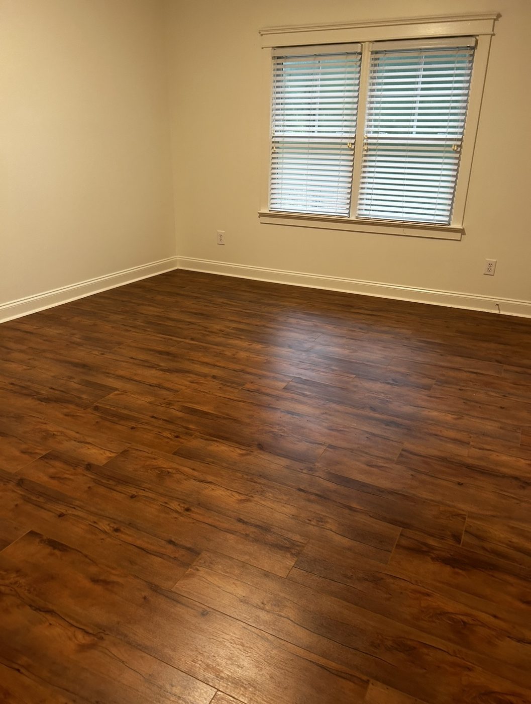 Bedroom with rich rustic walnut-tone wood-look flooring