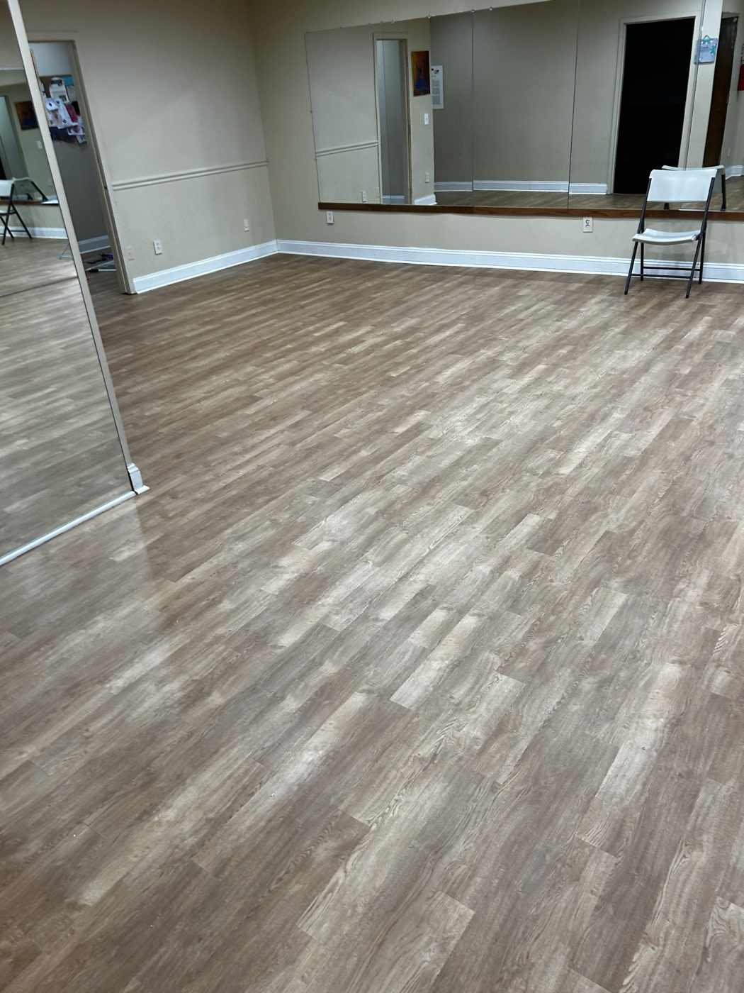 Wide-plank luxury vinyl in a dance studio with mirrored wall