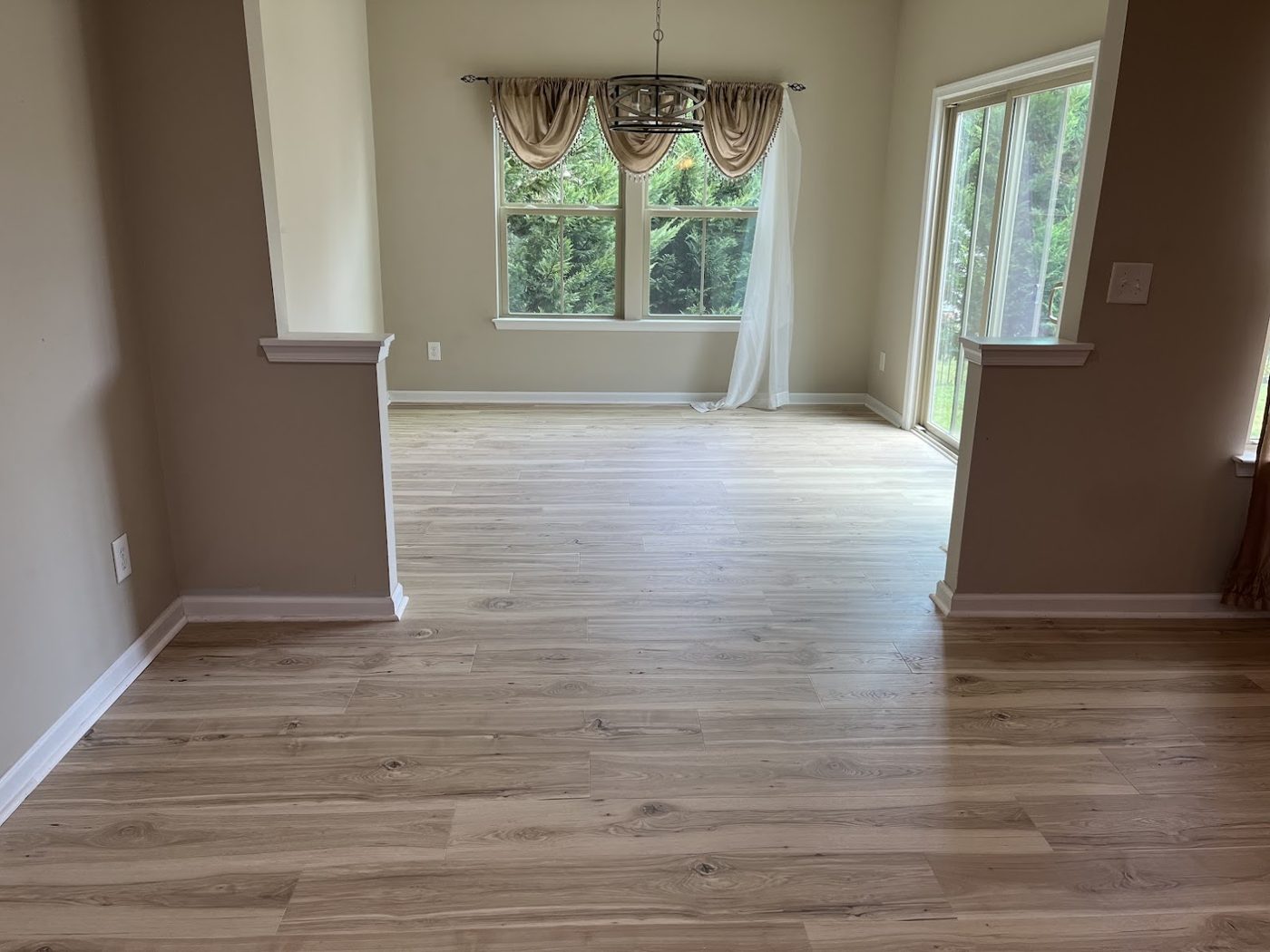 Dining room with light oak luxury vinyl plank flooring and natural light