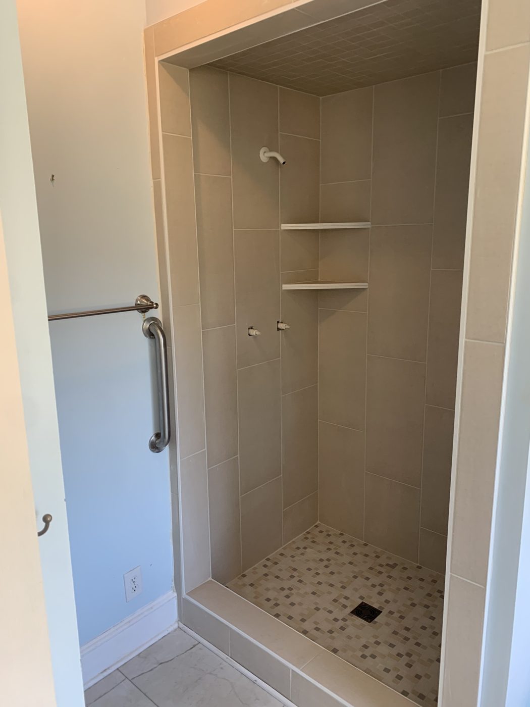 Custom tiled walk-in shower with mosaic floor detail
