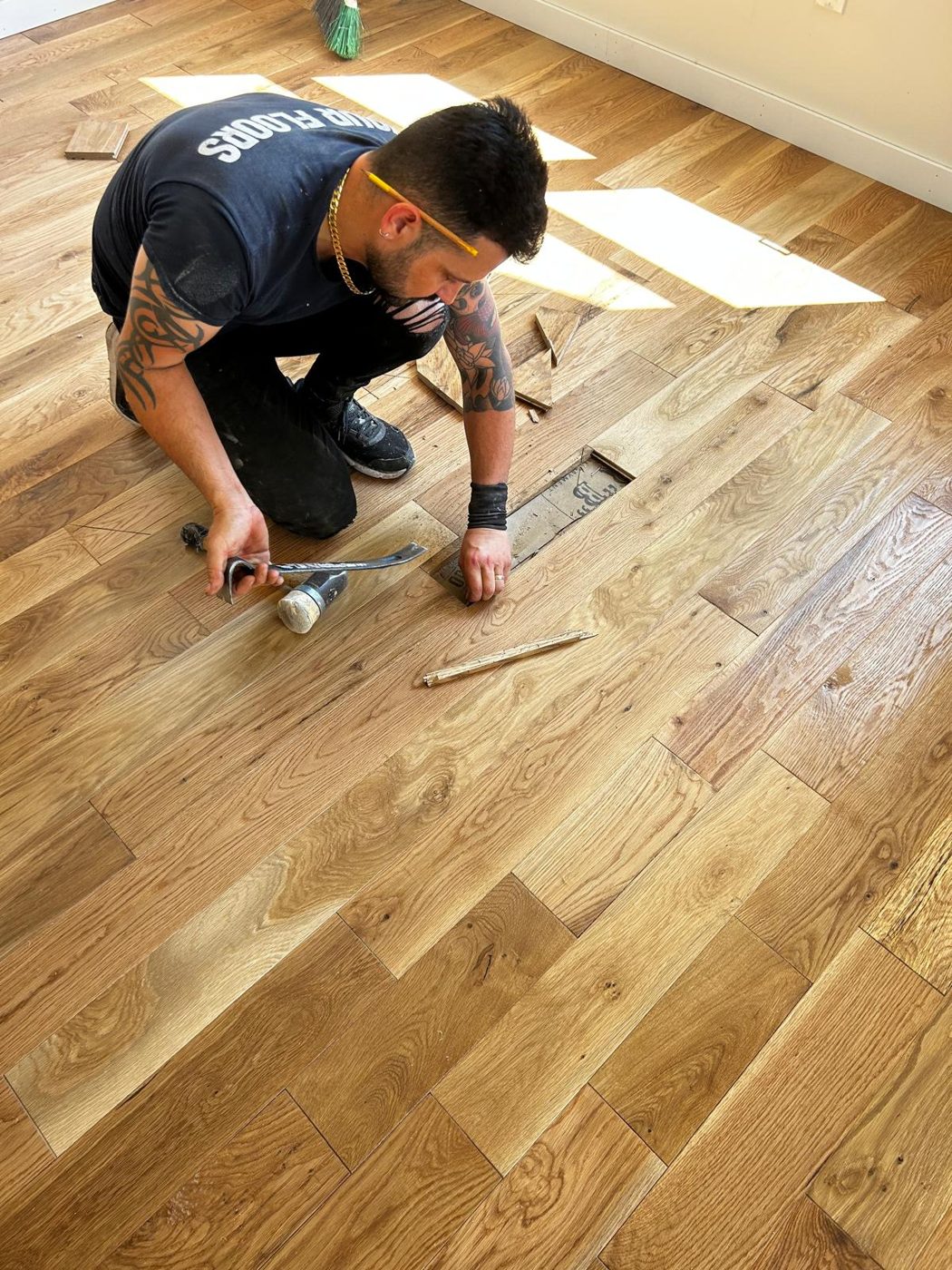 Installer fitting a white oak hardwood plank during installation