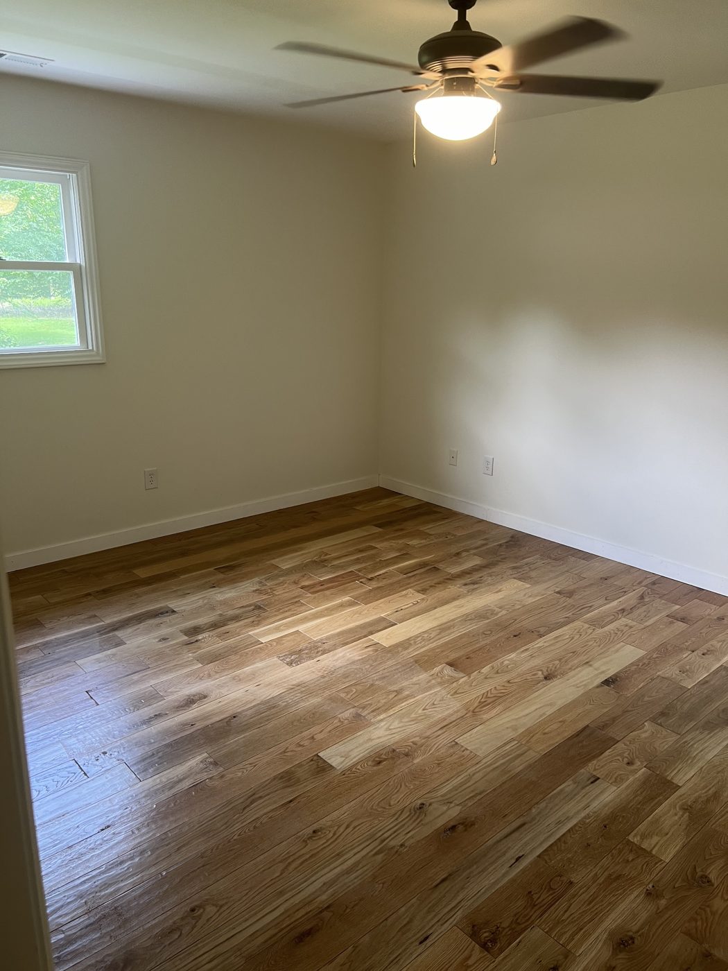 Natural hardwood flooring in a freshly painted bedroom