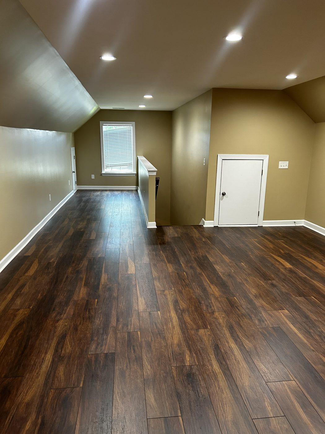 Dark hardwood flooring in a finished bonus room
