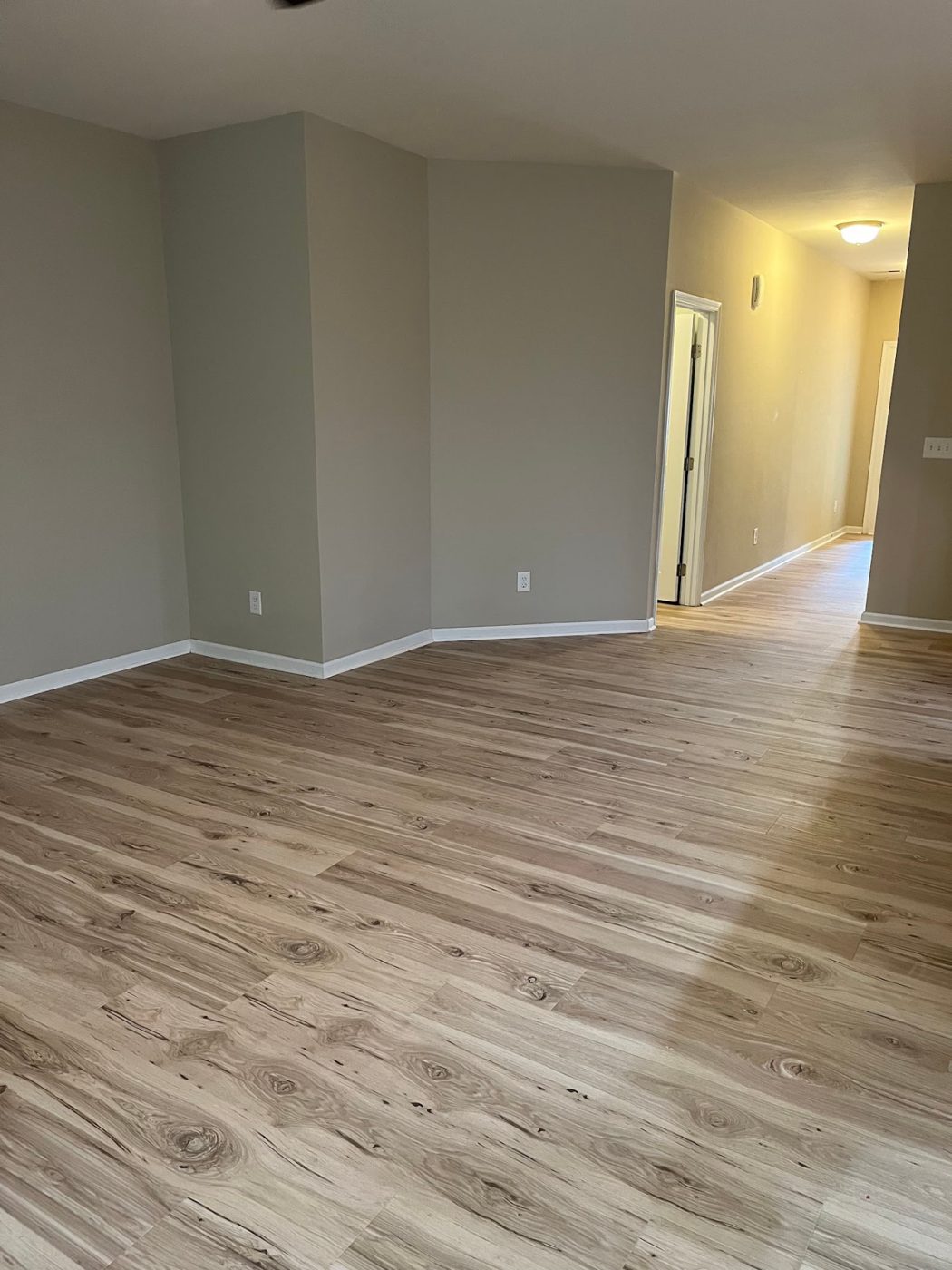 Open living area and hallway finished in light oak luxury vinyl plank