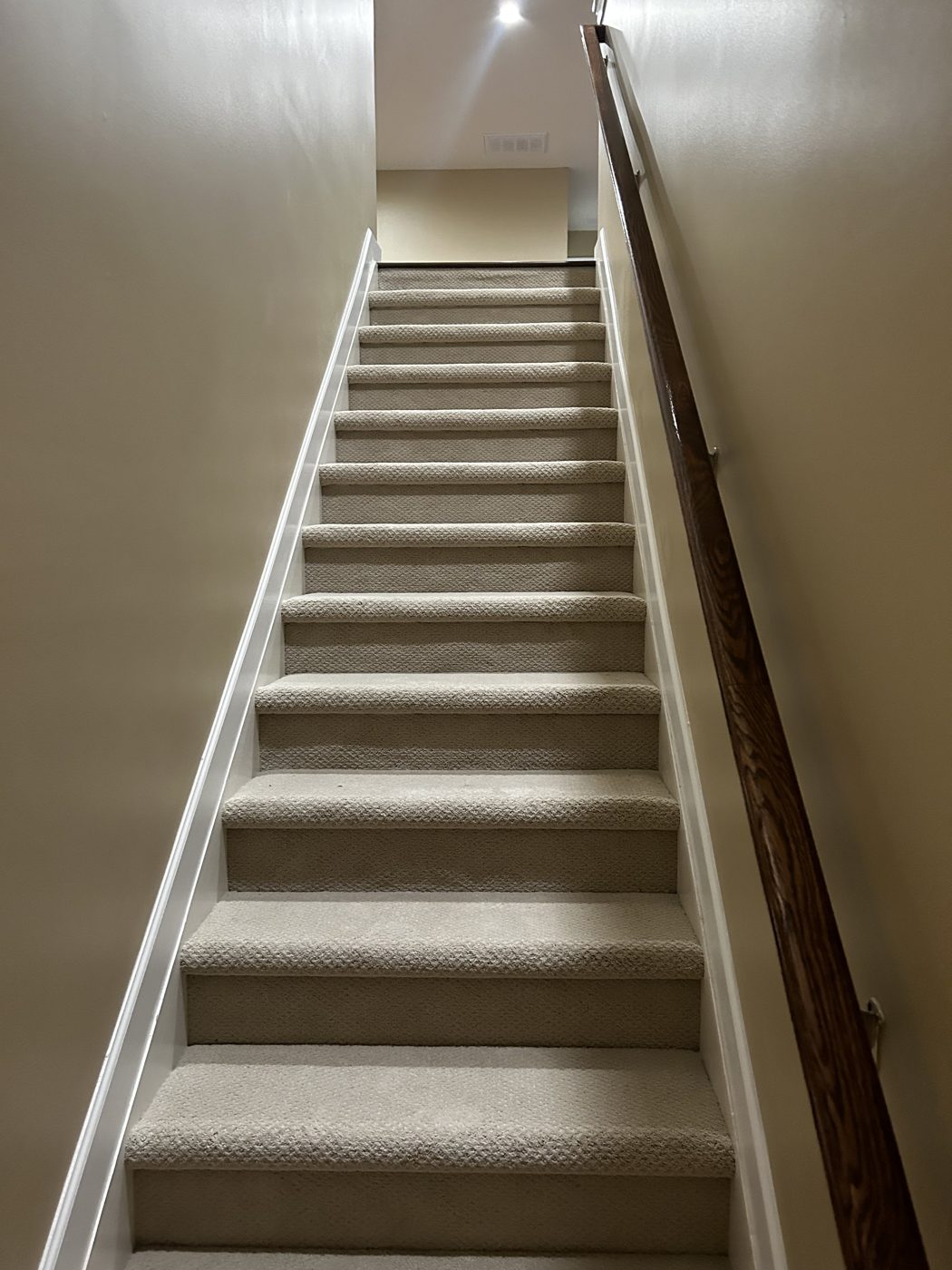 Gray carpet installed on a full flight of stairs